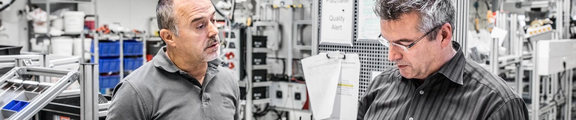 Zwei Baumer hhs Mitarbeiter kommunizieren in Produktion